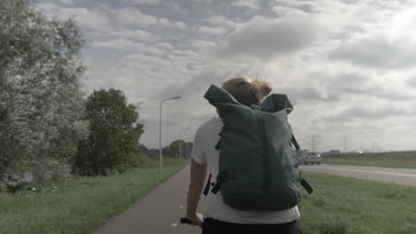 woman cycling on road in a typical dutch village countryside