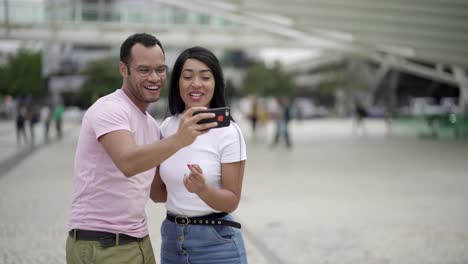 joven pareja feliz posando para un autorretrato en la plaza