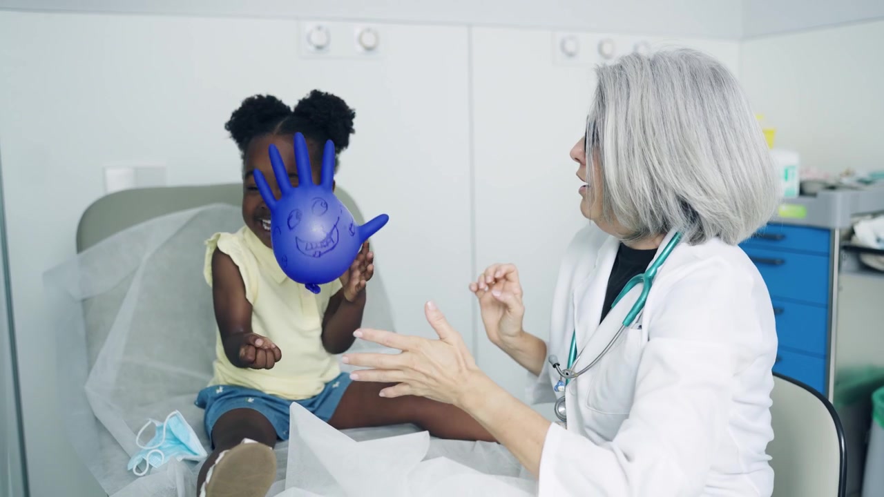 Vänlig barnläkare leker med ung patient på en klinik