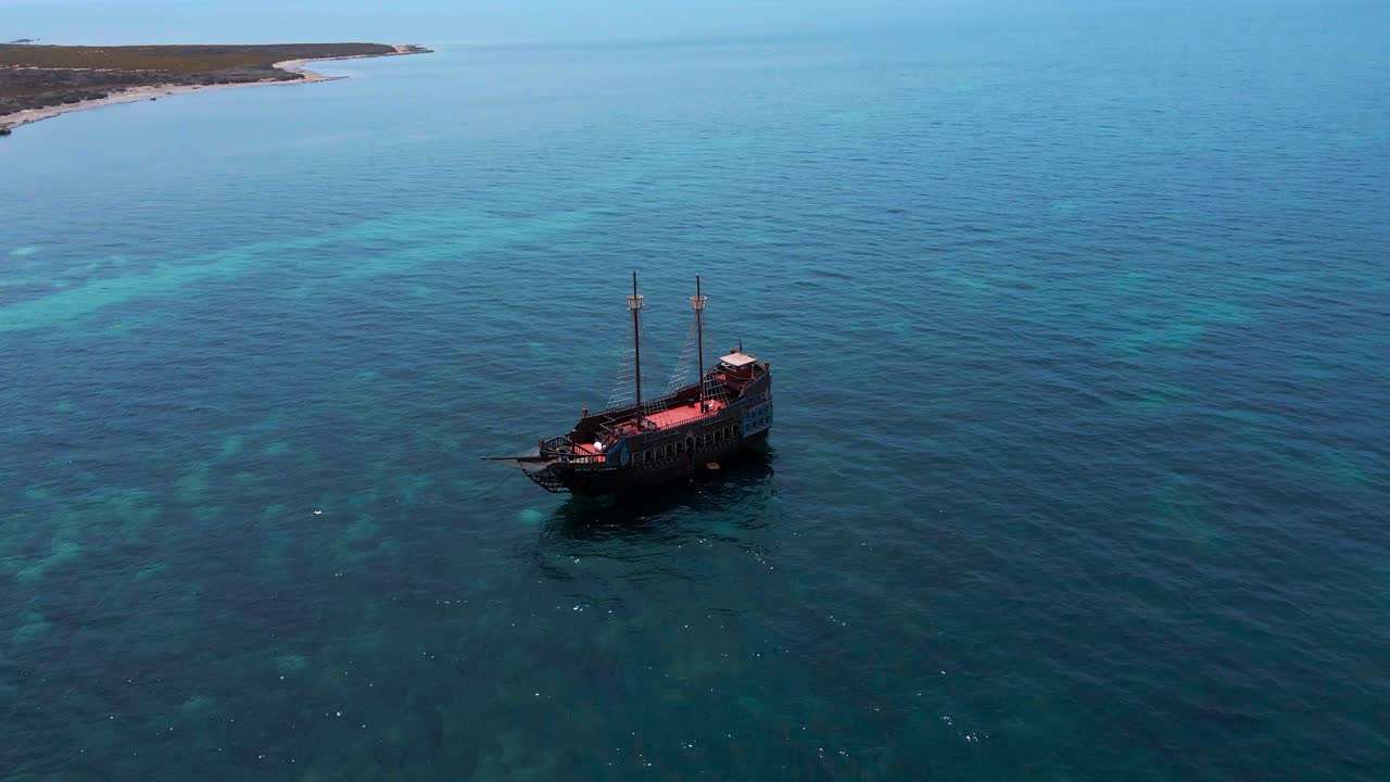 A lone cargo ship floats serenely on the vast, deep blue sea, embodying the silence and grandeur of maritime travel.