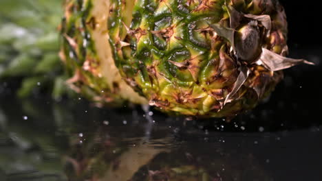 pineapple falling and splitting on black background