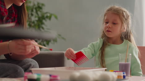 long haired girl draws pattern with comb on oily water