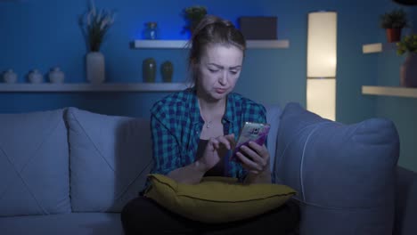 mujer deprimida en la noche enviando mensajes de texto por teléfono.