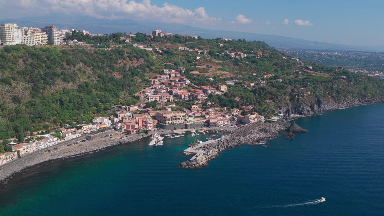 Veduta aerea panoramica di Santa Maria la Scala, un villaggio di pescatori circondato da scogliere di lava basaltica nera vicino all'Etna ad Acireale, Catania, Sicilia, Italia, una destinazione popolare sulla costa ionica