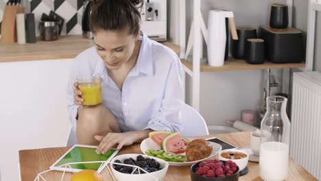 young woman using a tablet during breakfast