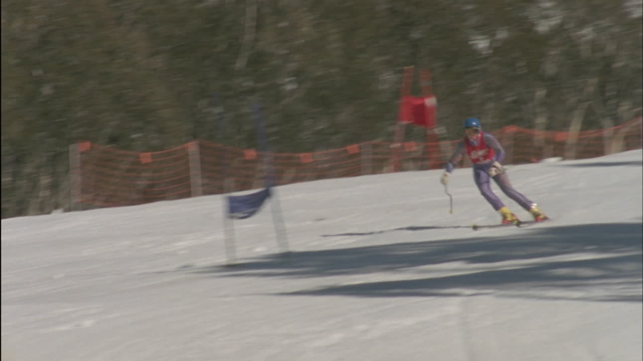 사람들이 지켜보는 가운데 스키어가 결승선에 도달합니다.