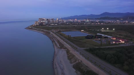 cinematic flight above sewage treatment facilities on the seashore at dawn after colourful sunset, batumi, georgia