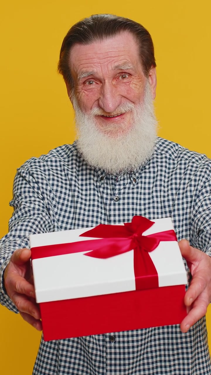 L'anziano sorridente presenta un regalo di compleanno la scatola di regali allunga le mani promozione sconto vendita