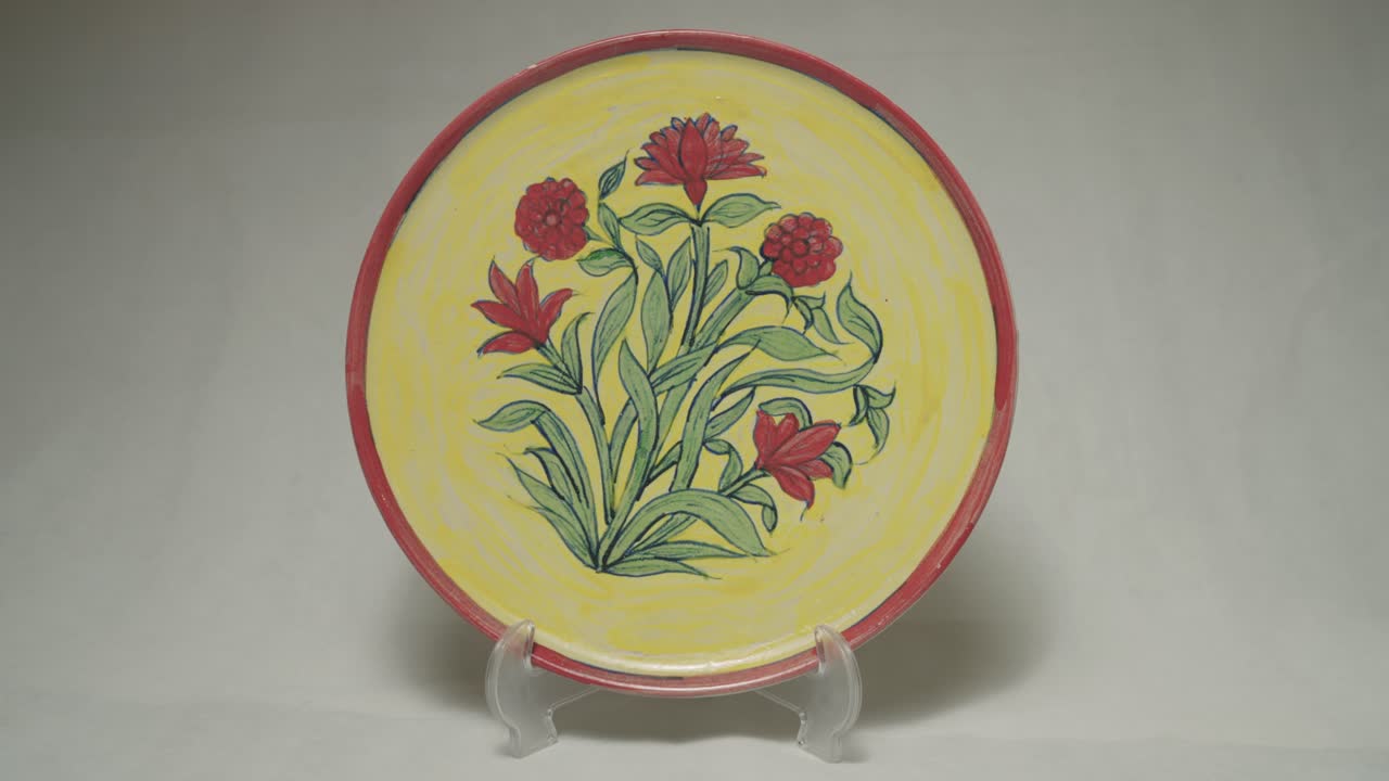 Decorative ceramic plate with floral design and vibrant colors presented on stand.