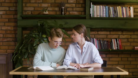 Young-teacher-and-blond-boy-in-glasses-reading-the-Bible