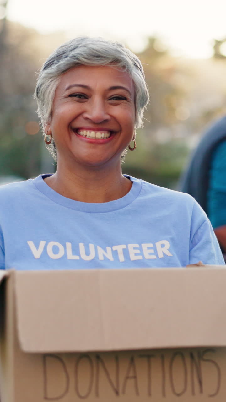 Happy Mature Woman Volunteer Holding a Donations Box
