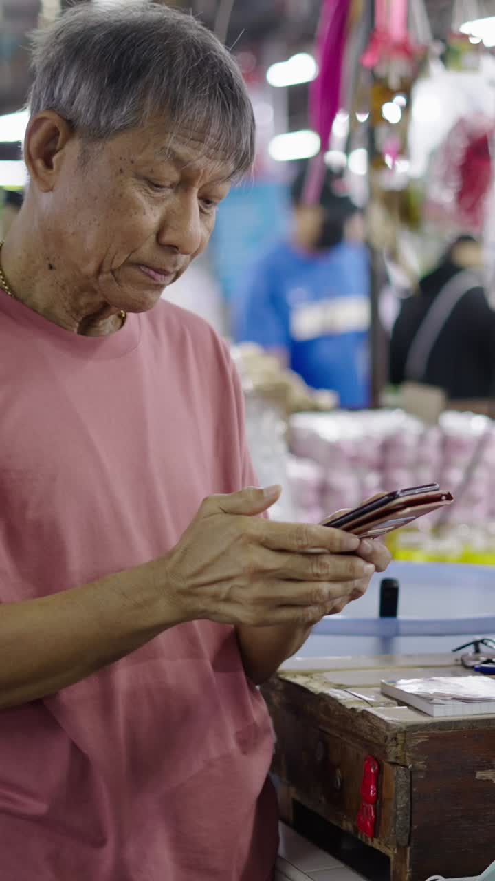 Senior man using smartphone at a market