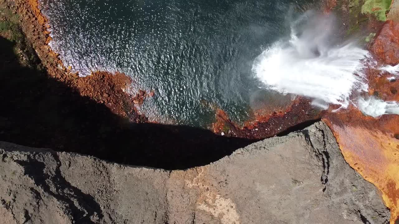 outstanding waterfall with orange and blue colors as the acid water flows in Salto del Agrio in Argentina