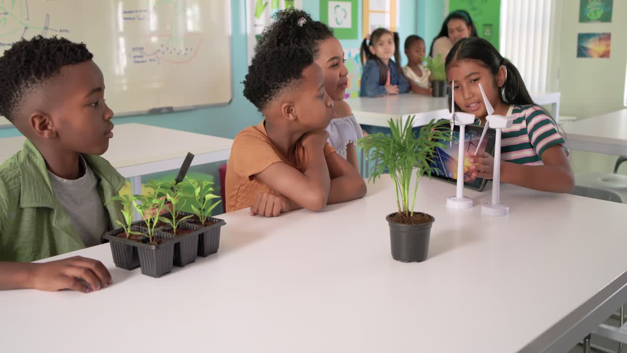 Colegas de classe diversos testando turbinas e ajustando as pás após a atualização do tablet para uma aula sobre energia