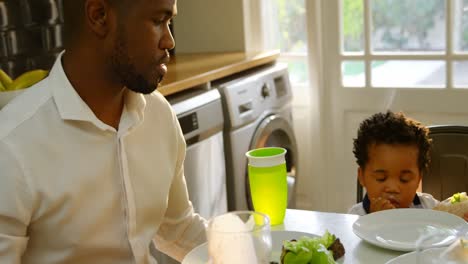 young black family having food at dining table in kitchen of comfortable home 4k