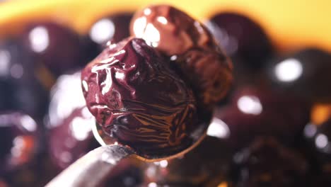 close-up of black olives on a spoon
