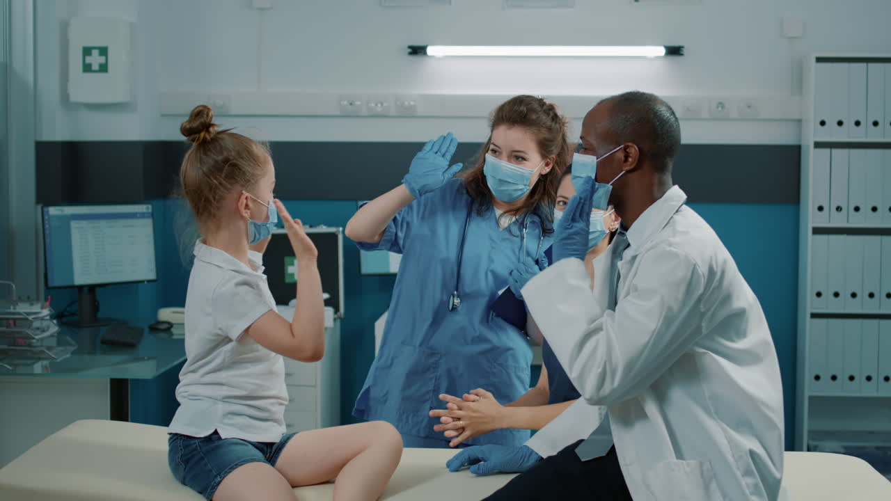 Professionisti sanitari che danno il cinque a un bambino