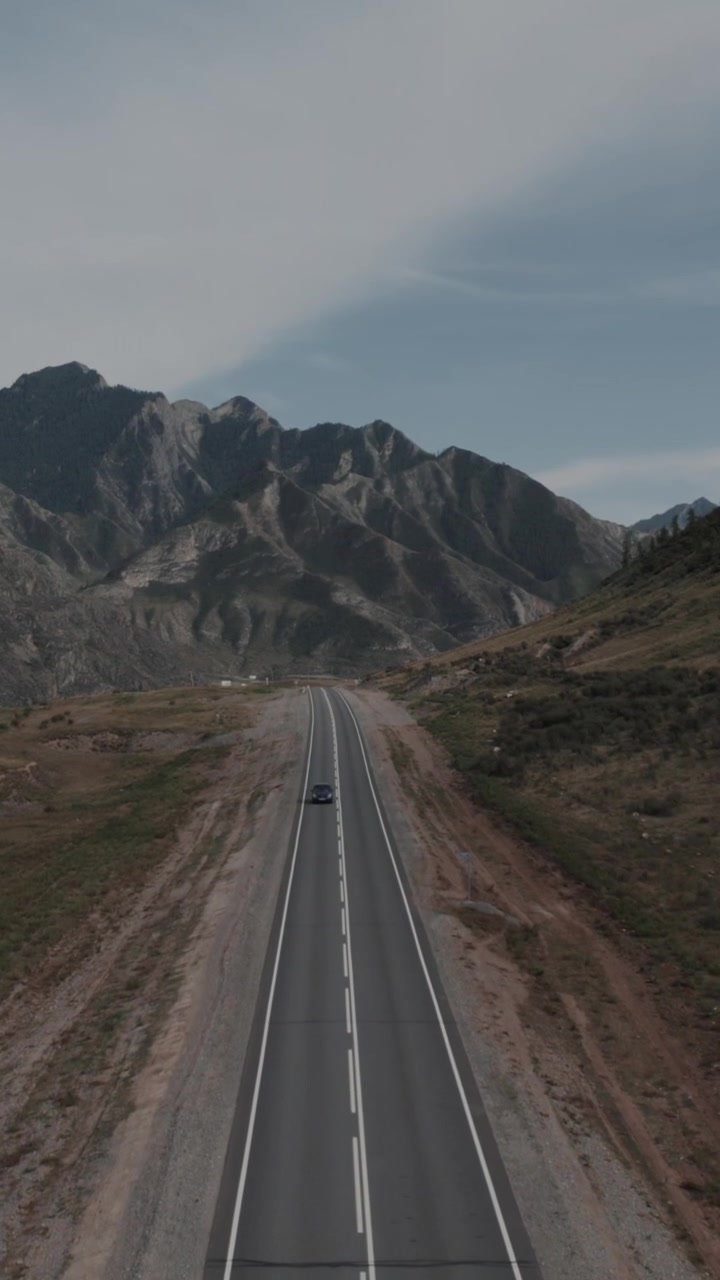 Vista aerea con drone di un tratto vuoto di autostrada asfaltata con doppia linea centrale e segnaletica laterale sulla Chuysky Trakt, Repubblica dell'Altai, Russia, concetto di viaggio e trasporto