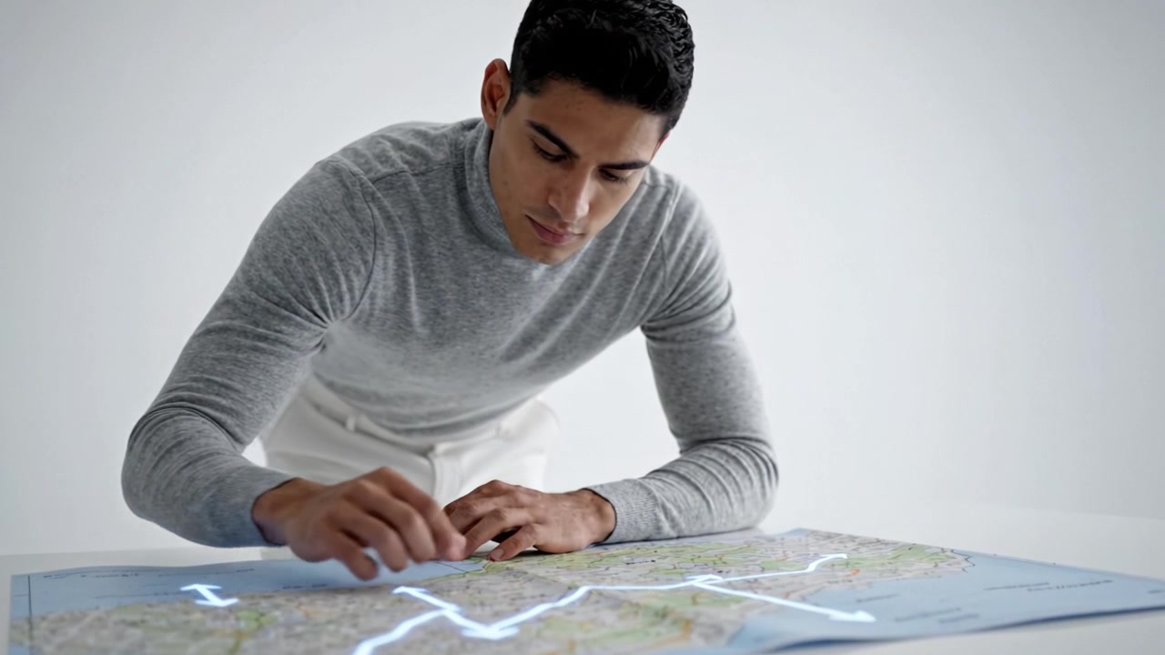 A focused individual analyzing a detailed map while illuminated by soft lights in a modern, minimalistic environment, showcasing concentration and direction finding.
