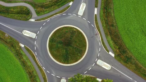 aerial view of traffic circle with green traffic island