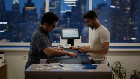 Engineers Assembling Components in a Modern Tech Lab at Night
