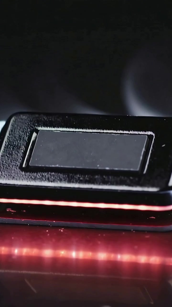 Video verticale: Telecamera in movimento che rivela un pulsante opaco su una scrivania da studio, con LED rosso che mostra la texture