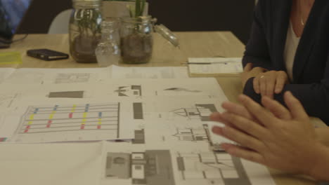 hands above floor plan in meeting