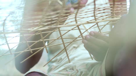 asiatic artisan making a hat with bamboo stick trunk sitting on the floor, asia cultural footage