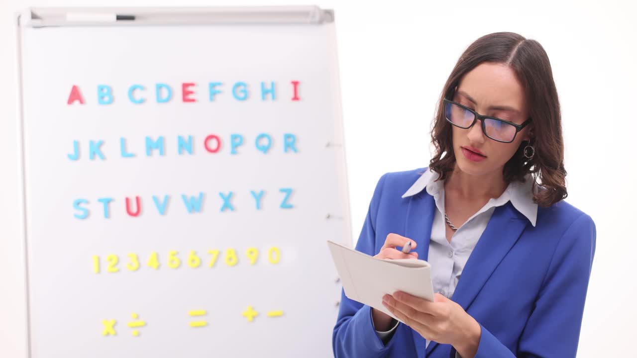 Woman Teacher Instructing with Alphabet and Numbers on Whiteboard