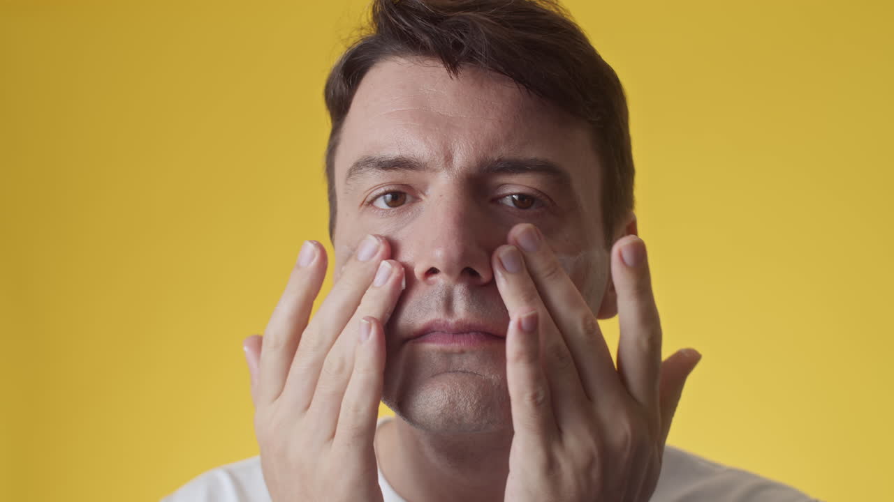 Gen Y Caucasian Man Applying Day Cream on Cheeks