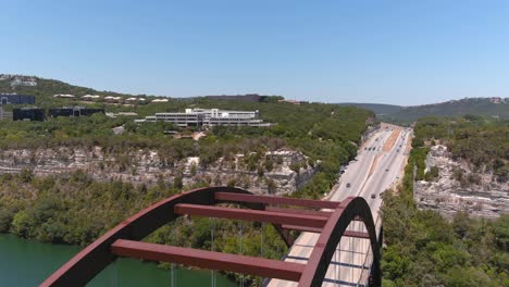 Al-Moverse-Hacia-Atrás-Se-Muestra-Una-Toma-Con-Un-Dron-Del-Puente-Pennyback-360-En-Austin,-Texas.