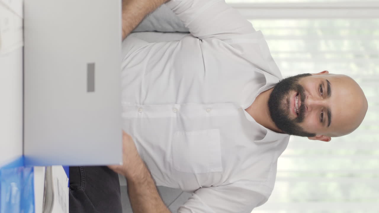 Video verticale di un uomo in smart working che completa il suo lavoro e si rilassa.