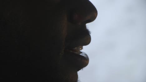 close up of black male singing to lyrics whilst working at work desk