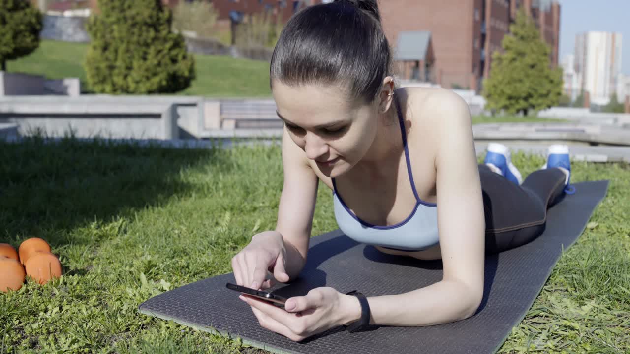 mujer usando su teléfono inteligente para encontrar nuevos ejercicios de fitness