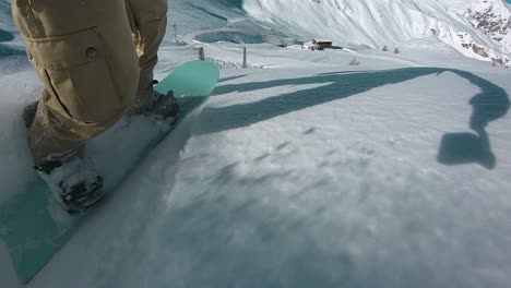 滑雪場上新鮮粉雪上滑雪板上的人的近距離拍攝