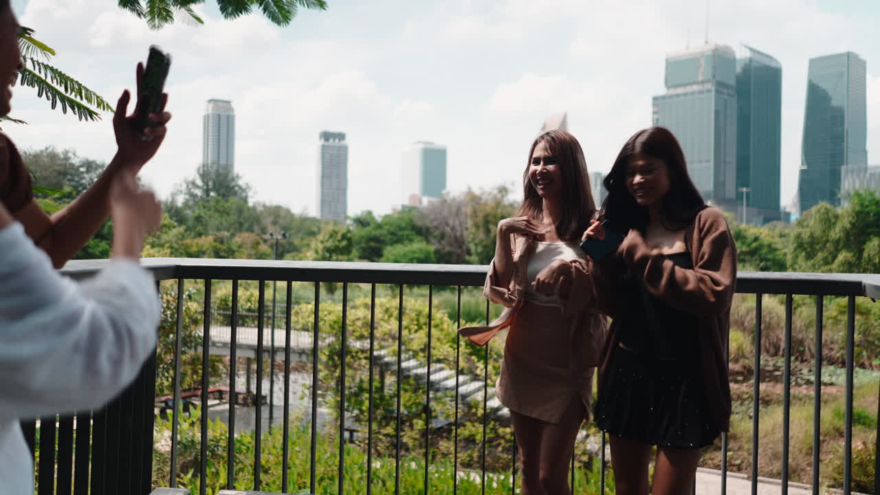 Young Women Posing for a Photo with City Skyline in Background