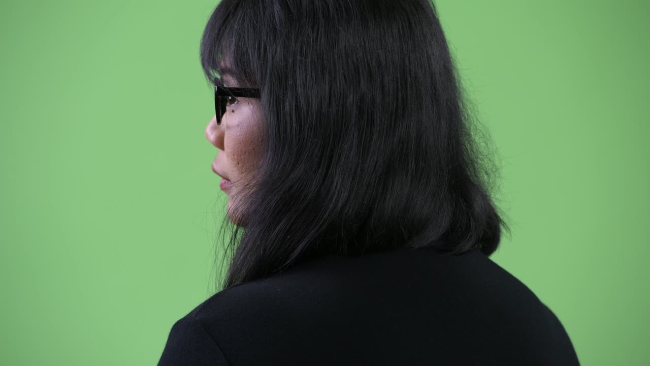 Beautiful Asian businesswoman looking back