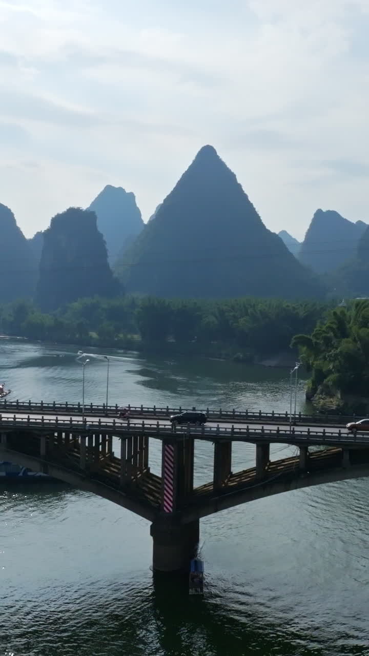 Portrait drone shot of traffic on the Yangshuo bridge, sunny day in China