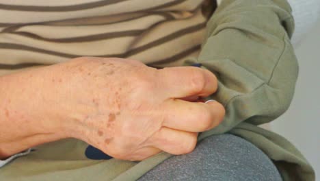 caucasian mature grandmother sewing a patch on her grandchild's pants