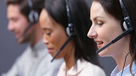 Smiling-customer-service-executives-talking-on-headset-at-desk-4k