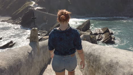 woman walking on a bridge near the sea