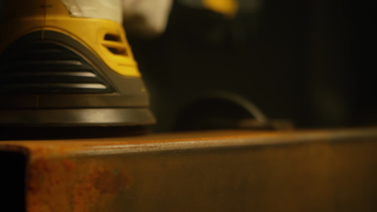 trabajador pulindo metal con un molinillo. interior de una fábrica de la industria pesada con un trabajador usando un molino. molienda eléctrica de tubos de acero en una fábrica. cámara lenta. up close. video 4k. filmado en rojo