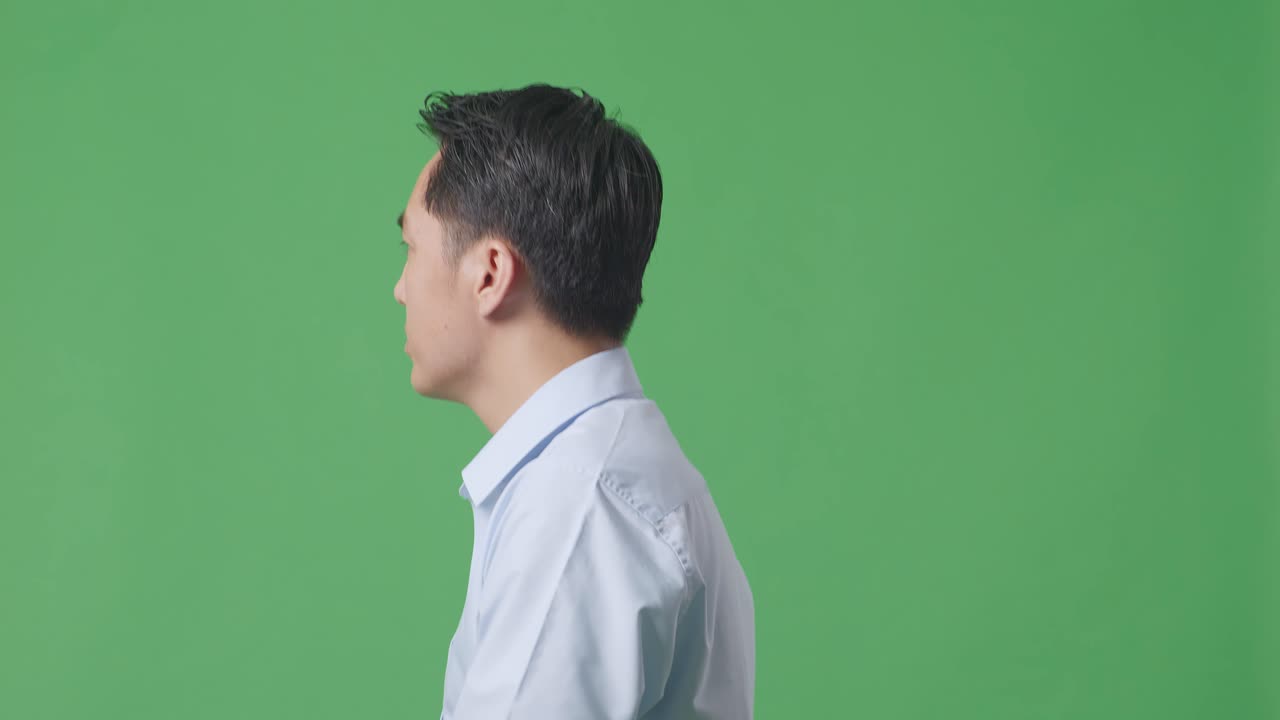 아시아 사업가가 가서 스튜디오에서 녹색 화면 배경에 둘러보는 측면 뷰 클로즈업