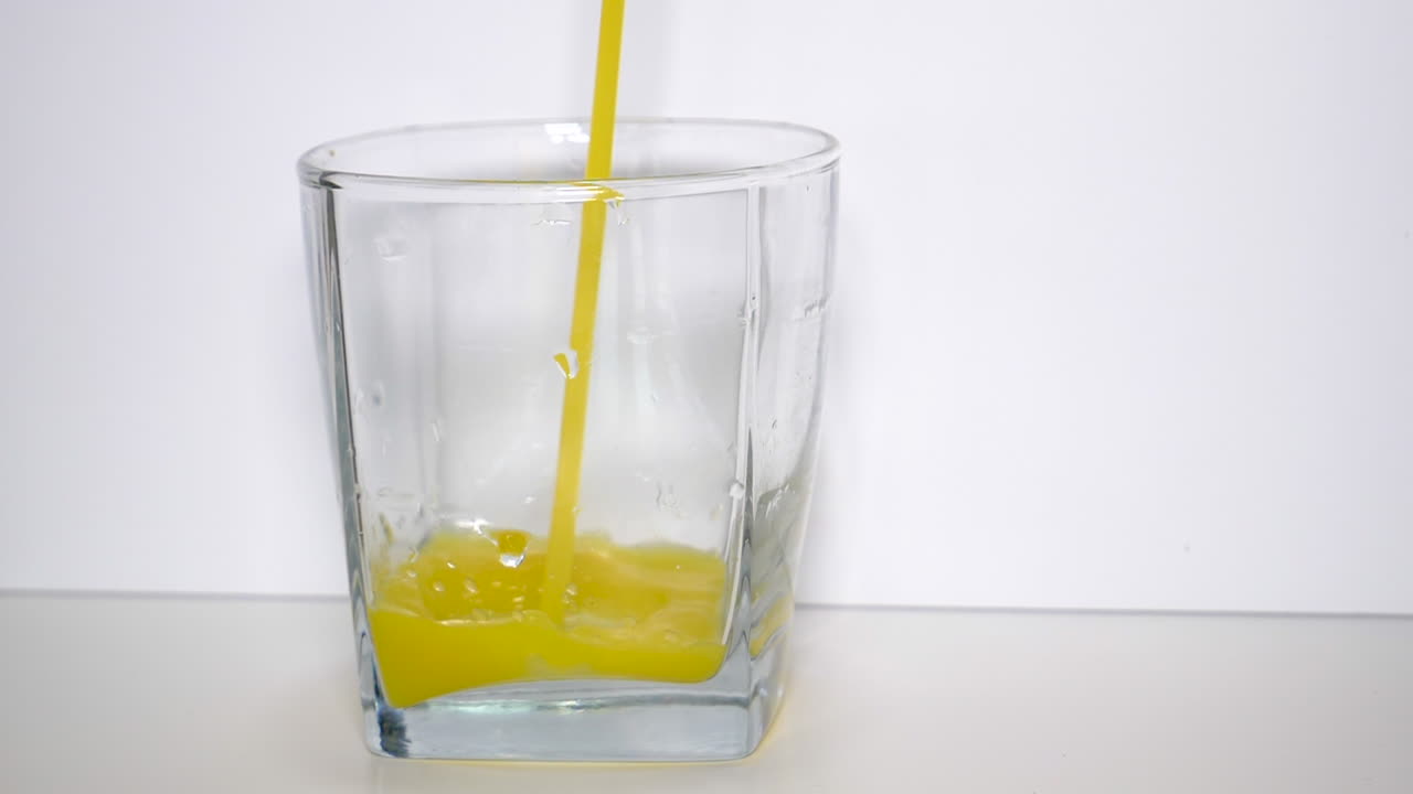 슬로우 모션으로 오렌지 주스 한 잔 붓기