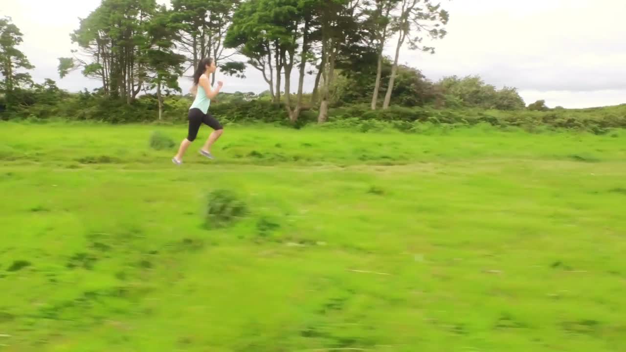 Fit woman running in a green landscape