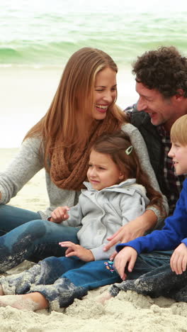 family sitting on the beach