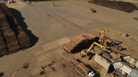 Excavadora-Levanta-Troncos-En-Fábrica-De-Papel,-Vista-Aérea-Giratoria