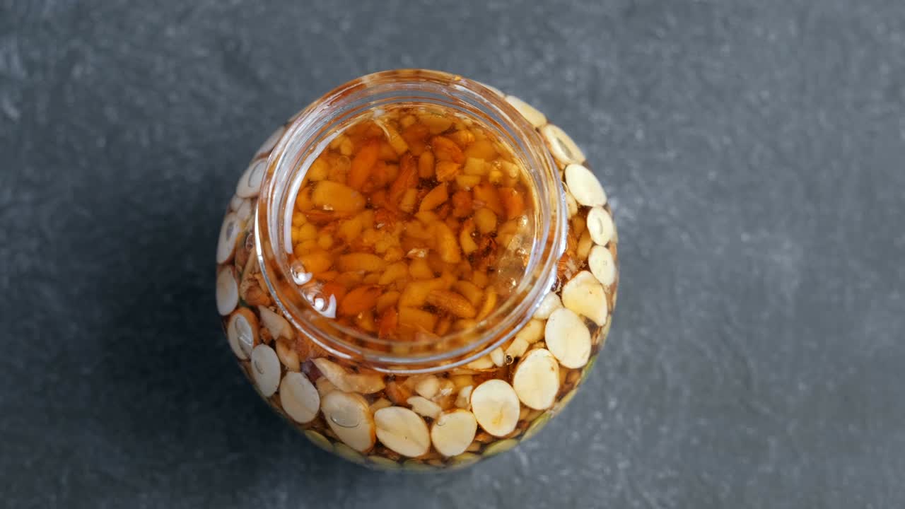 검은 테이블 위에 에 견과류를 넣은 항아리를 열어.