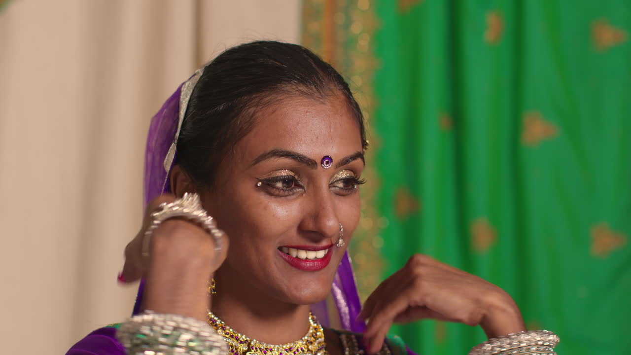 cabeza y hombros fotografía de estudio de una mujer sonriente bailarina de kathak realizando un baile vestida con un vestido tradicional indio