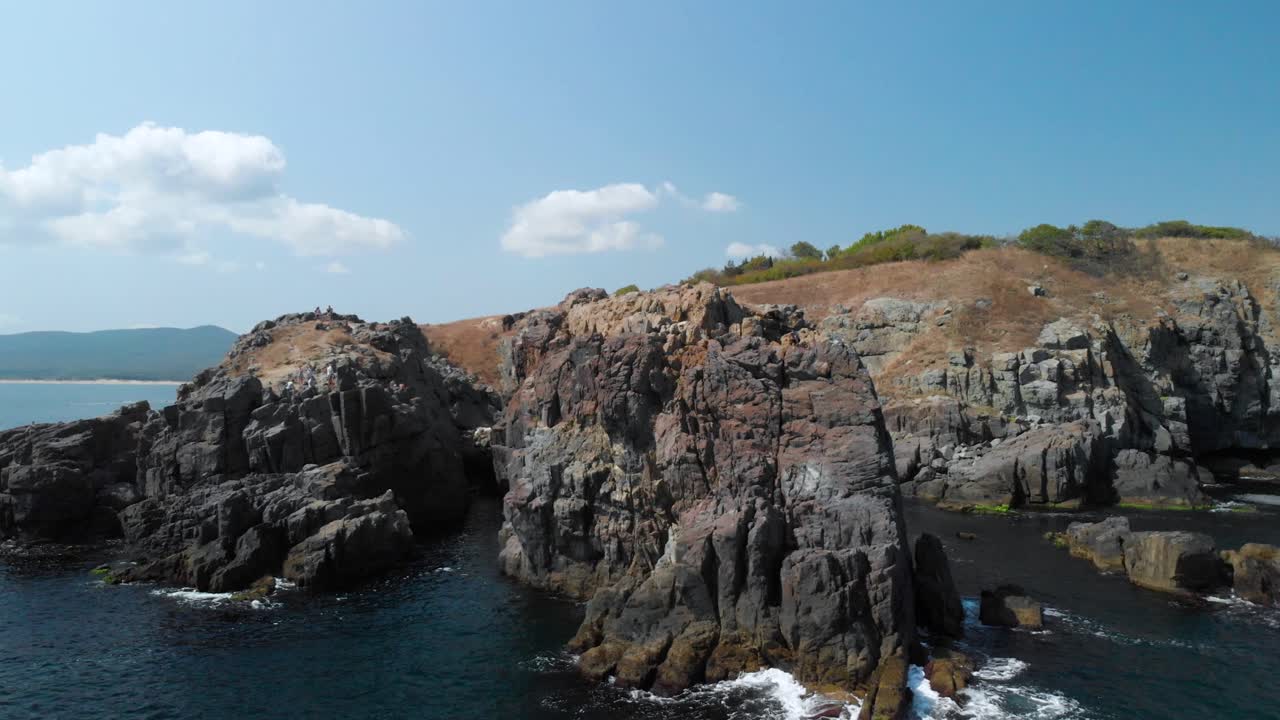 toma aérea de grandes rocas en el mar desde la orilla del mar en un día soleado de verano